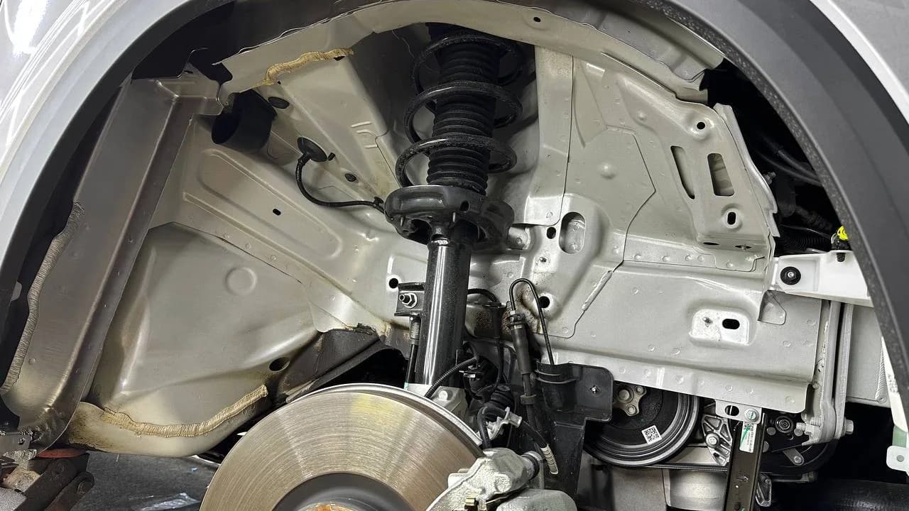 Передняя подвеска Geely Monjaro со снятым колесом и подкрылком